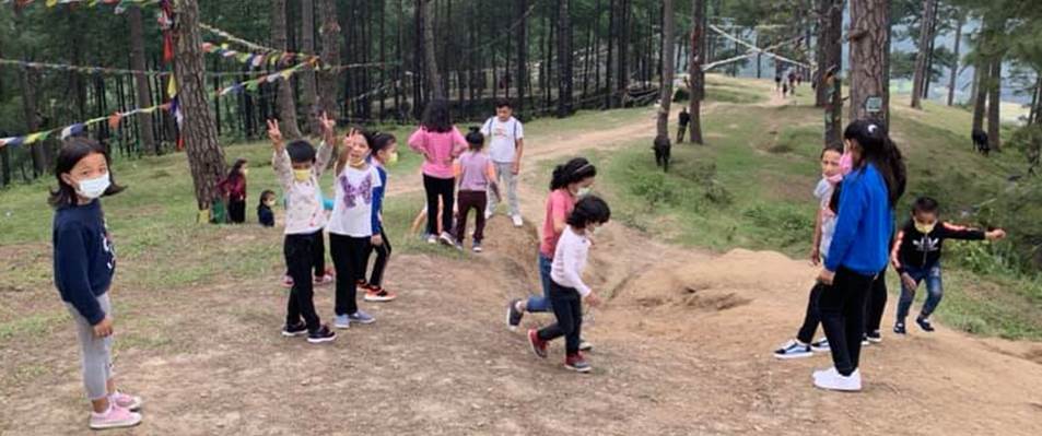A group of children walking on a dirt path in a forest

Description automatically generated with low confidence